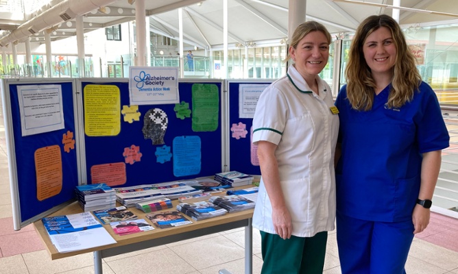 Image shows two women and a display board