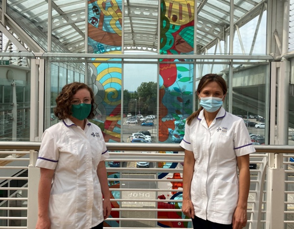 Two women standing inside a hospital