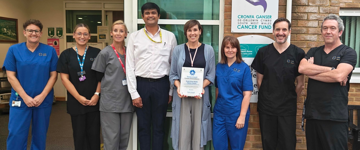 Image shows a group of clinicians outside a hospital building.