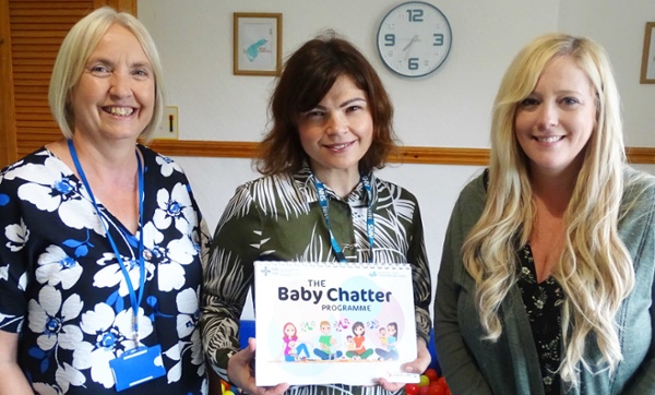 Image shows three people, one holding a Baby Chatter booklet.