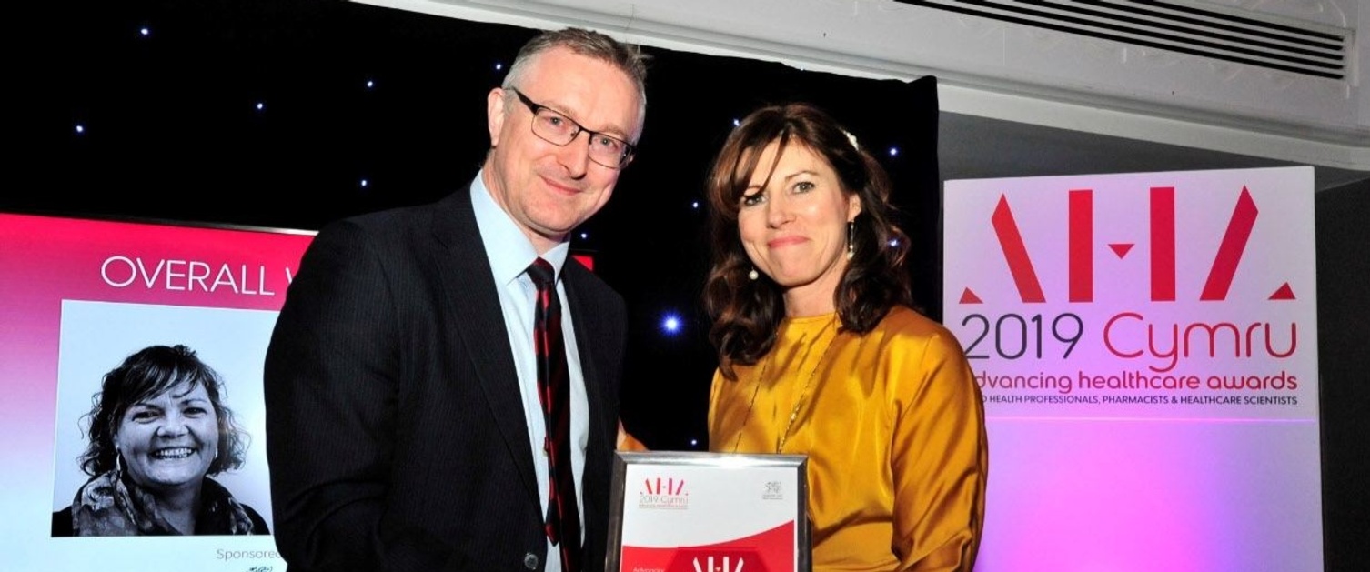 Amanda Atkinson receives the overall winner award from NHS Wales Chief Executive Andrew Goodall. Image credit: John Behets.