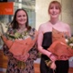 Image shows two women with bouquets of flowers