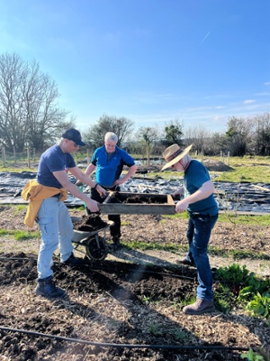 Image shows three men at a farm