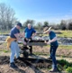 Image shows three men at a farm