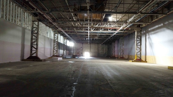 Image shows interior of a large, empty factory.