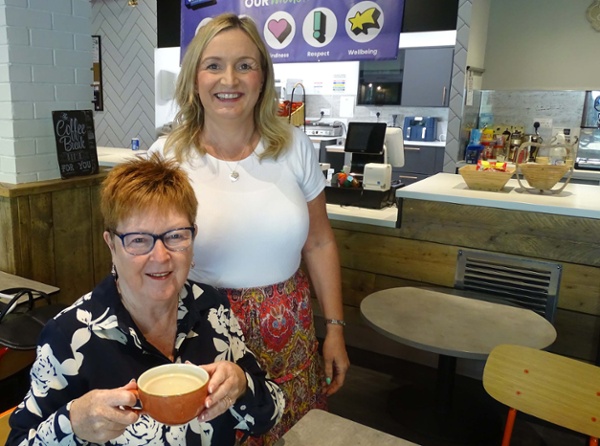 Image shows two people in a cafe.