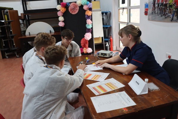 A group of children working on a school project with a nurse