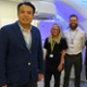 Image shows a group of clinicians standing in a radiotherapy treatment room