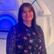 Image shows a woman standing inside a radiotherapy room.