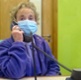 Image shows volunteer wearing face mask talking on a telephone