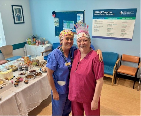 Image shows two women standing in front of a table