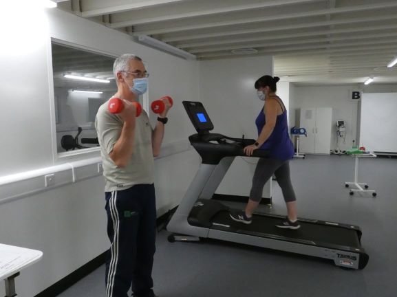 Patients lifting weights and walking on a treadmill