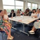 Image shows a group of people sat around a table