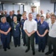 A large group of people, in different staff uniforms, stood inside a new hospital department