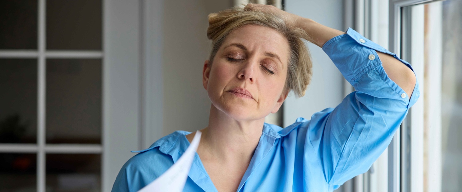 A woman cooling herself with a piece of paper