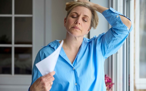 A woman cooling herself with a piece of paper