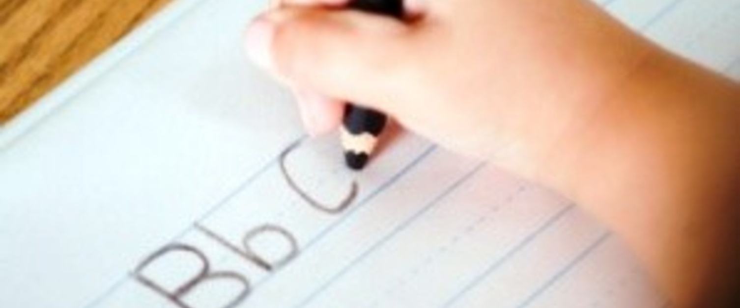 A child practising writing the alphabet