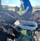 Image shows a man shovelling compost into a wheelbarrow