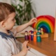 An image of a young boy and a female teacher learning and playing with colourful toys.