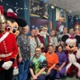 Santa, hospital staff, soldiers and Mickey Mouse smiling in a hospital ward