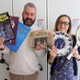 Library staff hold up old vinyl albums, a copy of the Daily Sketch newspaper from the Queen