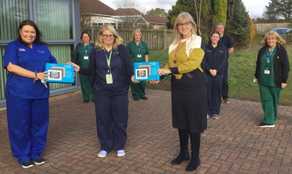 Staff members in group present memory clocks to Sue Williams