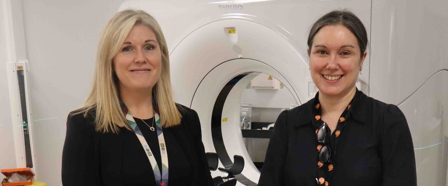 Image shows two clinicians in a radiotherapy treatment room