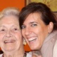 Older and younger woman smiling together.