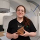 Image shows a smiling woman holding an award.