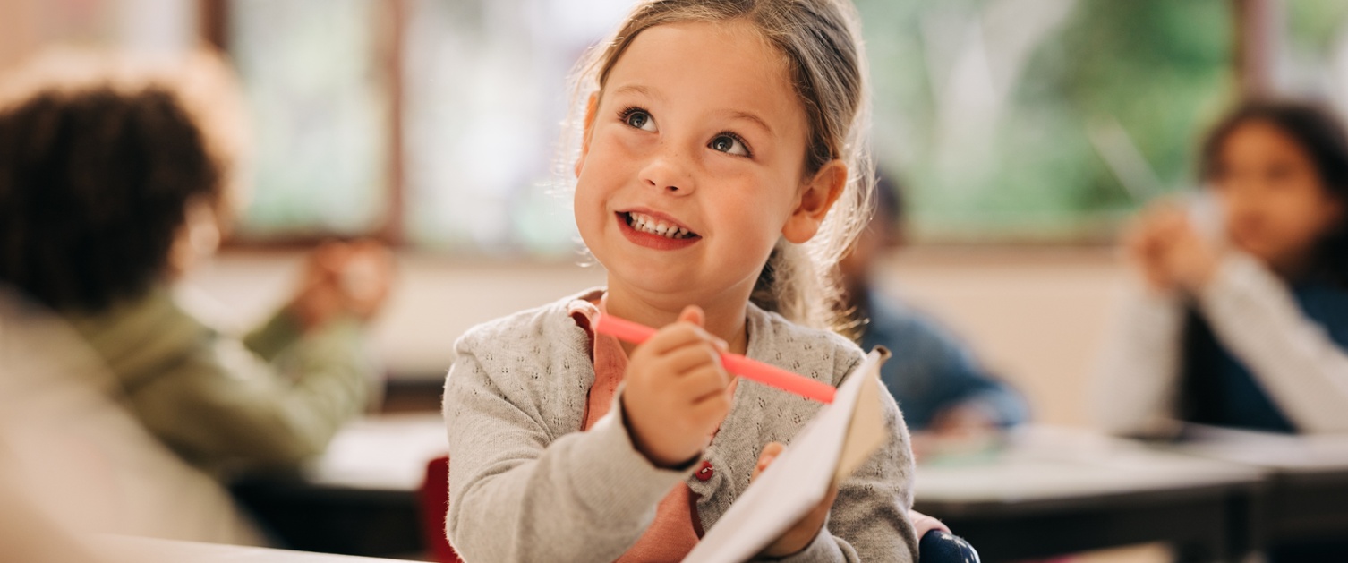 Image shows a child in a classroom.