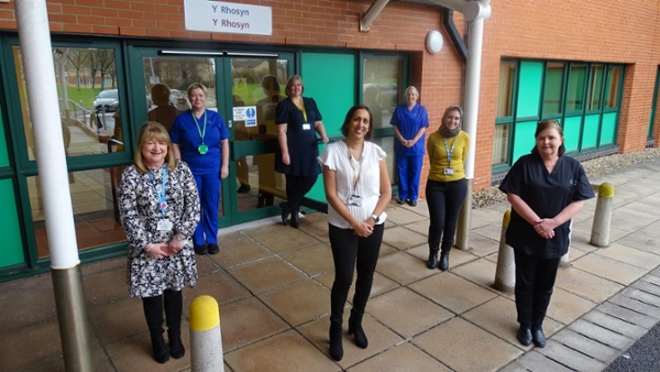 Image shows a group of staff outside a hospital