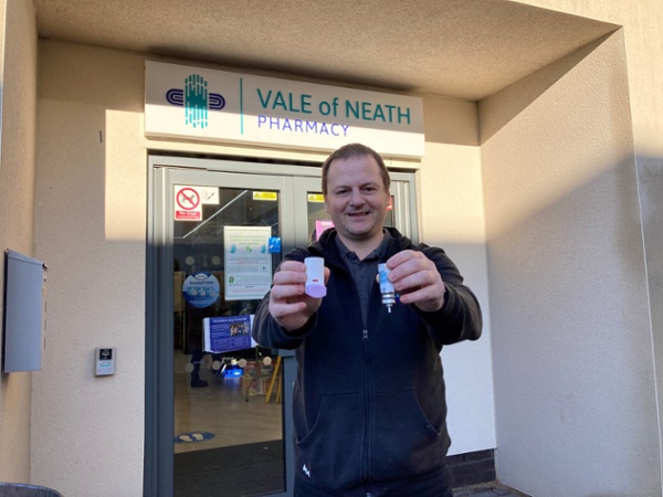 Image shows a man holding an inhaler
