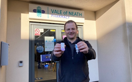 Image shows a man holding an inhaler