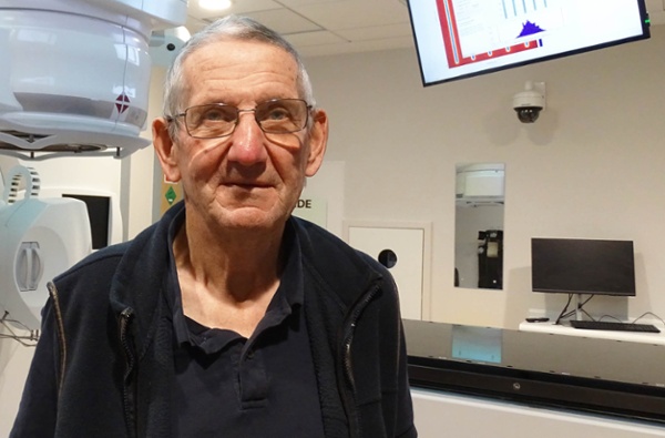Image shows a patient in a radiotherapy room.