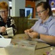Image shows two people doing arts and crafts in a cafe.