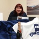 Image shows a woman with raffle prizes.