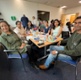 Image shows a group of people sat around a table