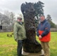 Image shows two men in front of a tree