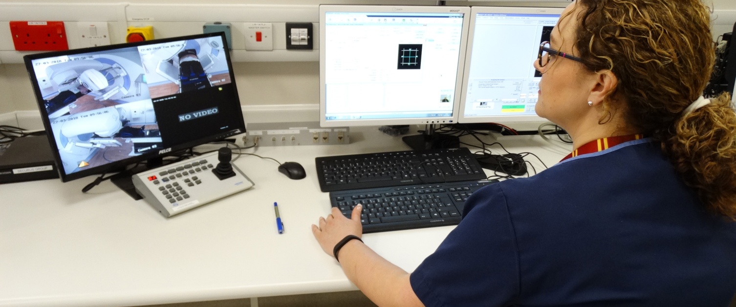 A radiographer works at a computer.