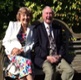 Image shows an elderly couple sitting on a bench.