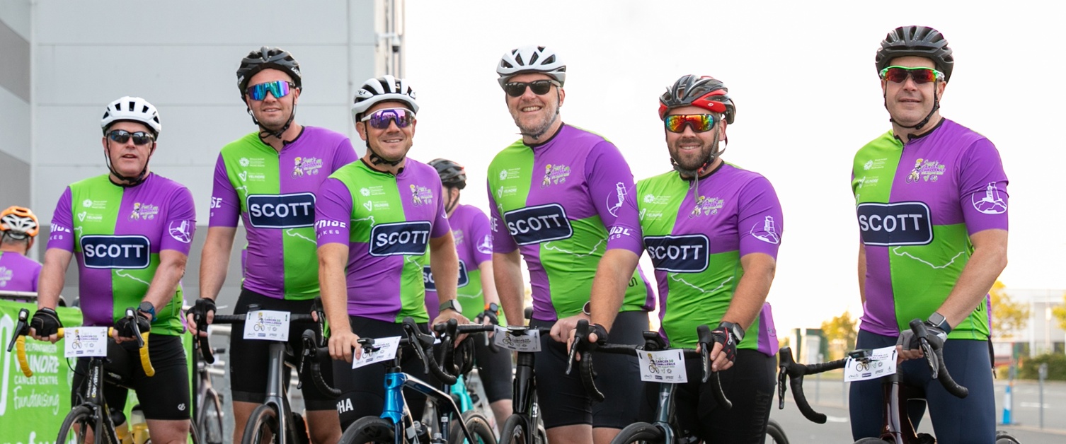 A group of cyclists smiling and getting ready to ride off