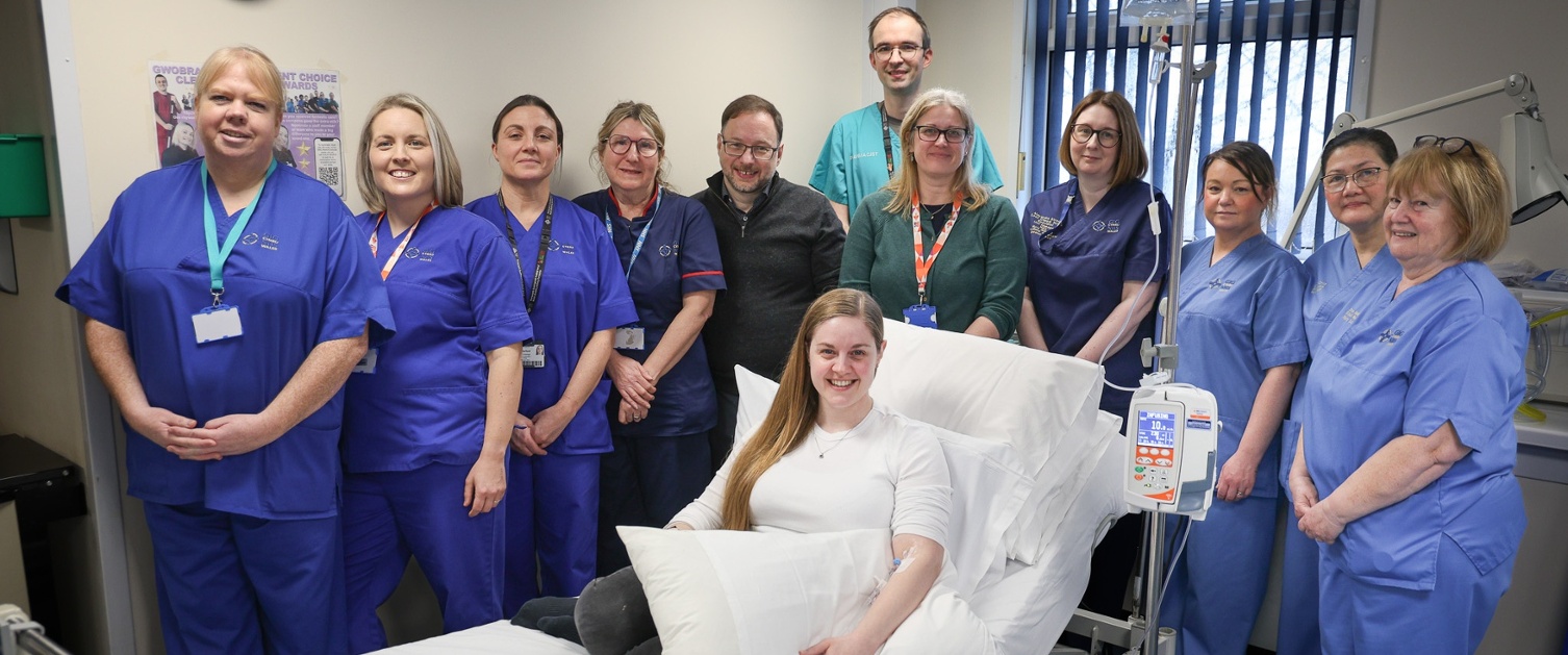 Fiona sat in a hospital bed surrounded by members of staff