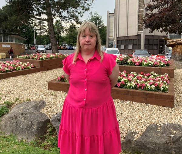 A woman standing next to a flowerbed