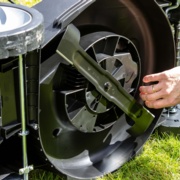 Image shows close up of fingers by lawnmower blade.