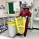Image shows a man holding a bag on a hospital ward