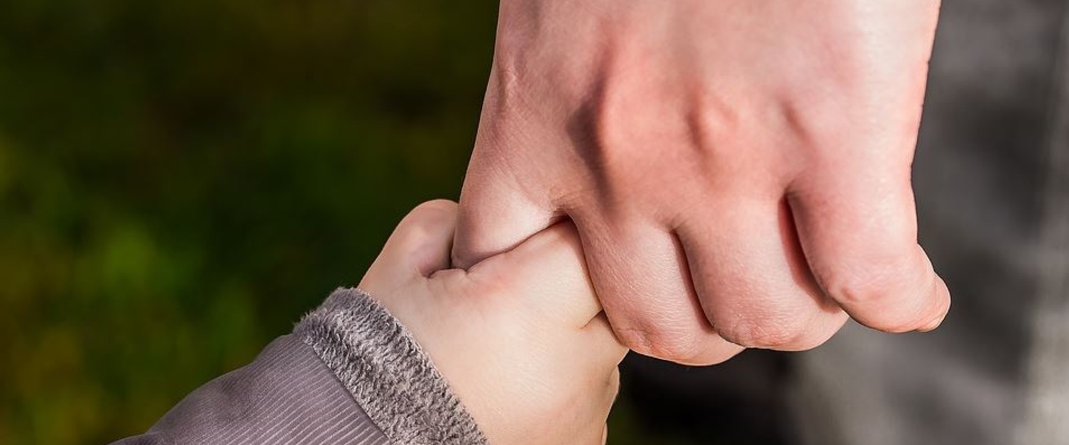 A parent and child holding hands