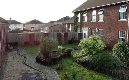 The garden at Gorseinon Hospital as it was in February 2020. The plants are overgrown and a raised flowerbed is in a state of disrepair.