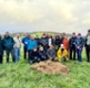 Image shows a group of people standing in a field