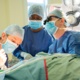 The surgeons conducting an operation in theatre.