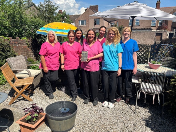 The Talbot Road Dental team stood in their garden with an award